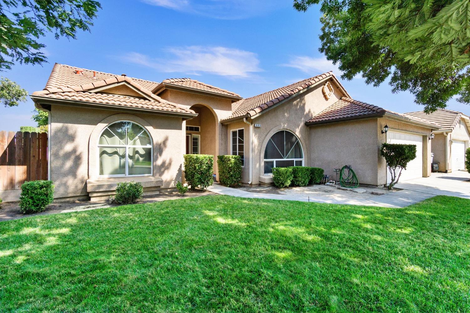 595 Quady Lane Madera, CA 93637 - Photo 3 of 25 a front view of a house with a garden and plants