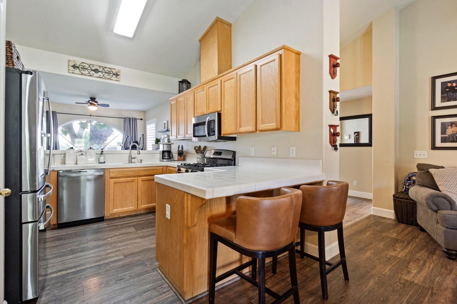 595 Quady Lane Madera, CA 93637 - Photo 10 of 25 a kitchen with stainless steel appliances granite countertop a table chairs sink and cabinets
