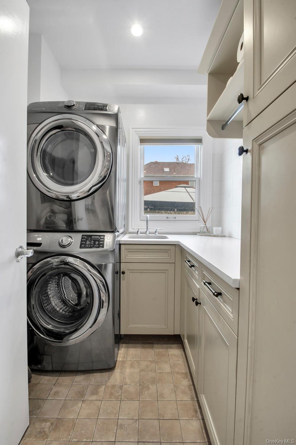 102 Shore Road Queens, NY 11363 - Photo 9 of 22 Laundry room with stacked washer and clothes dryer, cabinet space, and recessed lighting, located on the 1st floor