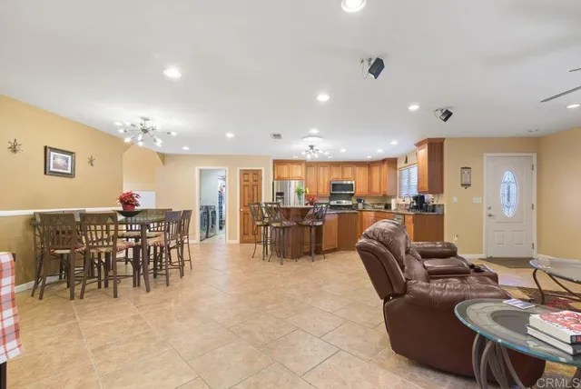 a kitchen with stainless steel appliances kitchen island granite countertop a dining table chairs and granite counter tops