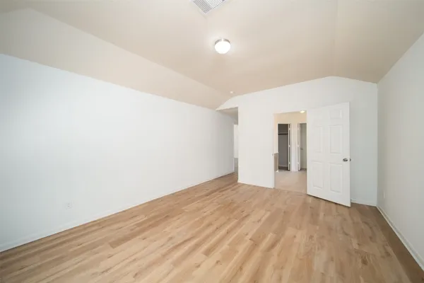 a view of an empty room with wooden floor