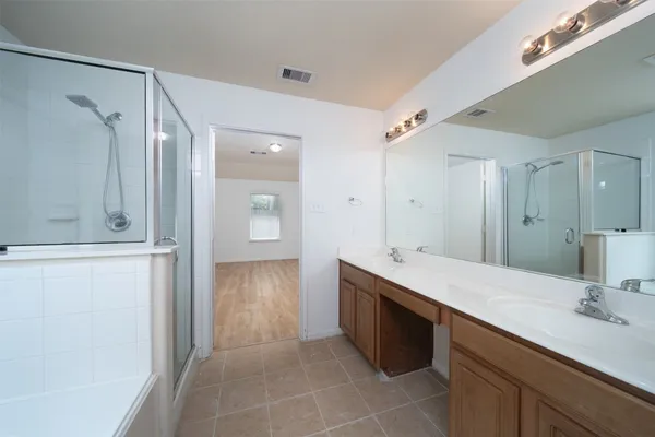 a bathroom with a double vanity sink mirror and shower
