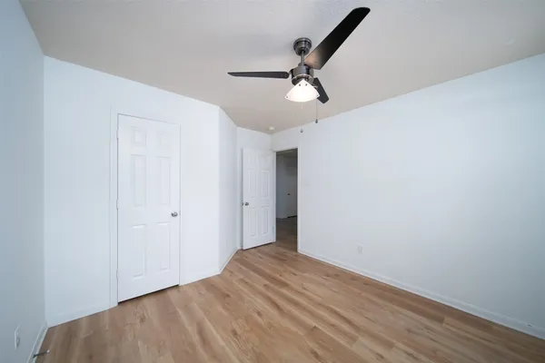 a view of a big room with wooden floor and windows in a room