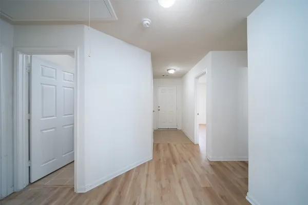 a view of a hallway with wooden floor