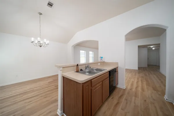 a kitchen with a stove and wooden floor
