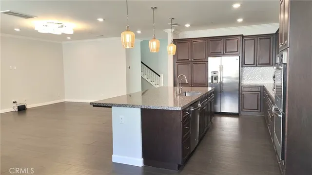 an empty room with wooden floor and windows with curtains