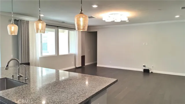 a kitchen with granite countertop a sink a counter top space and living room