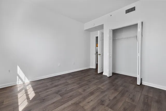 an empty room with wooden floor and closet
