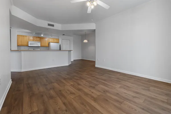 a view of a room with wooden floor and a ceiling fan