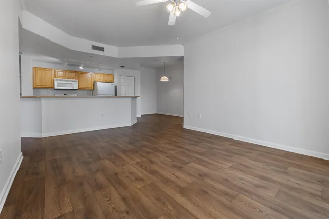 a view of a room with wooden floor and a ceiling fan