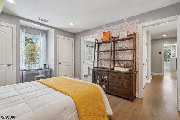 a bathroom with a granite countertop toilet a sink a mirror and a window