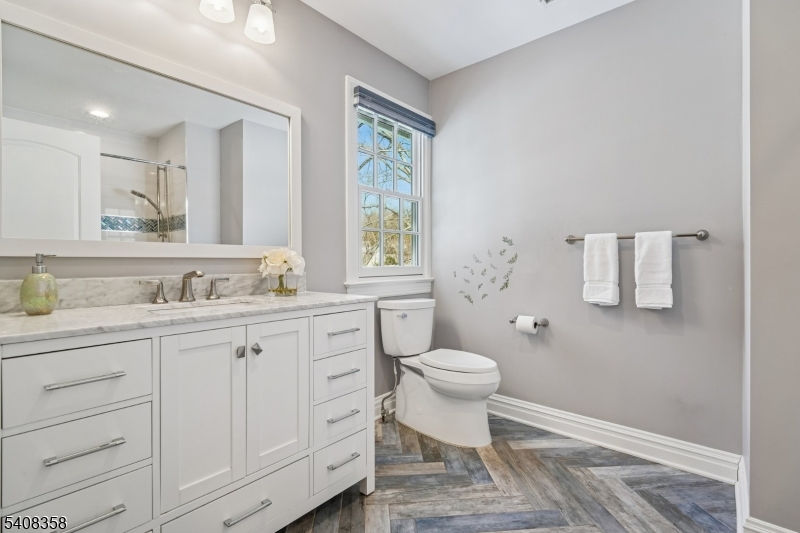 5 Farley Road Short Hills, NJ 07078 - Photo 15 of 26 a bathroom with a granite countertop toilet a sink a mirror and a window