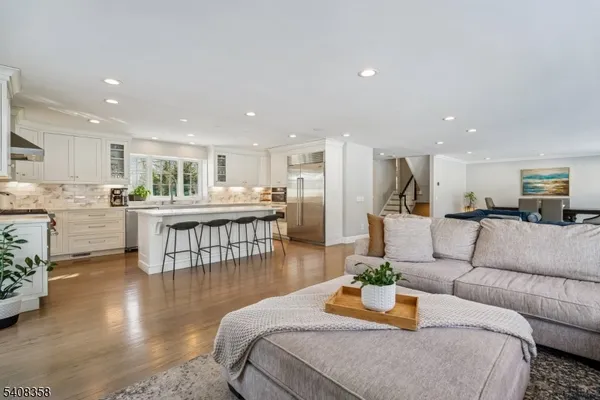a living room with furniture and a dining table with kitchen view