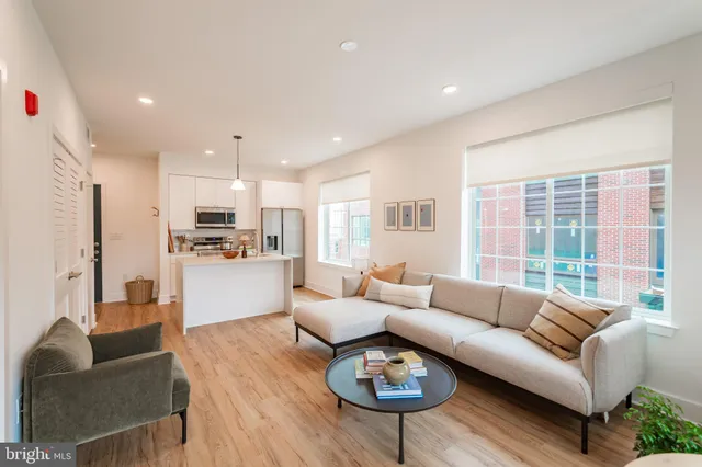 a living room with furniture kitchen and a large window