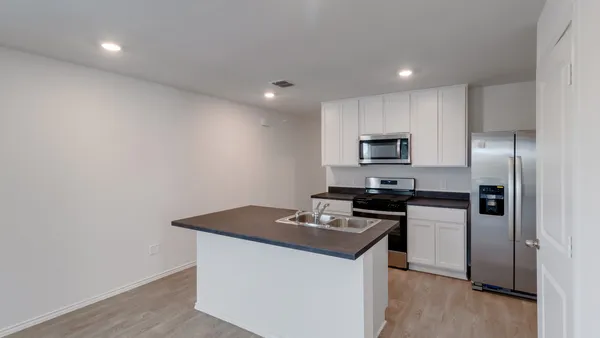 a kitchen that has a sink and a stove top oven