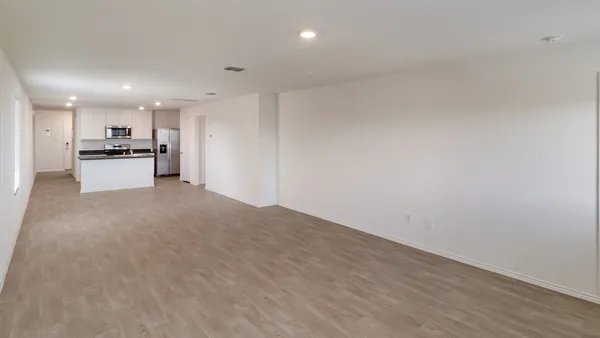 a view of a kitchen with a sink and dishwasher a refrigerator with wooden floor