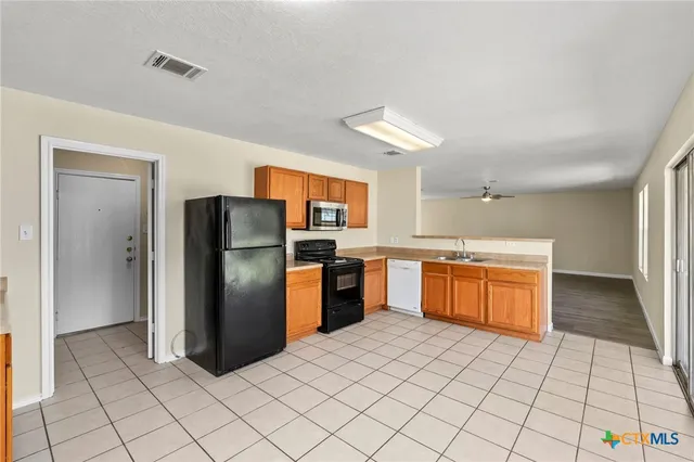 a kitchen with stainless steel appliances granite countertop a refrigerator and a sink