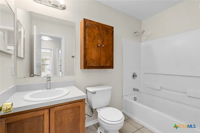 a bathroom with a granite countertop sink a toilet and shower