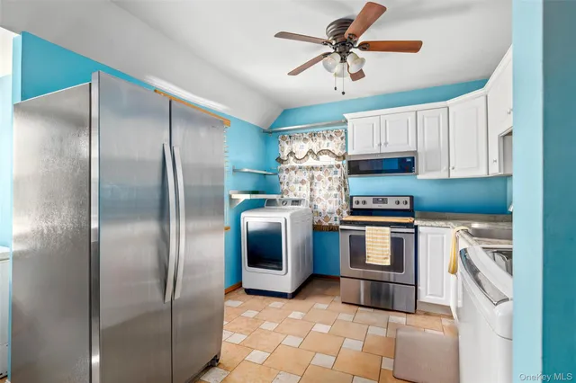a kitchen with stainless steel appliances granite countertop a refrigerator a stove and a sink with cabinets