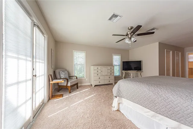 a bedroom with a large bed a flat screen tv and a couch