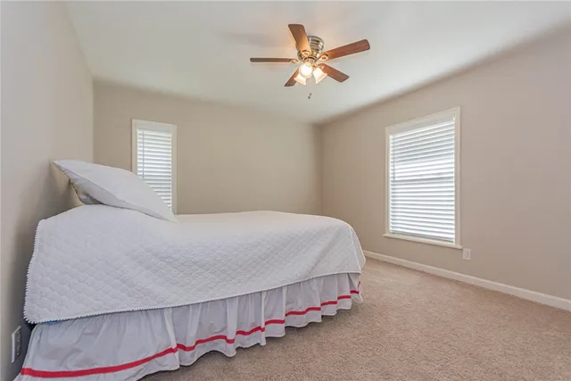 a bedroom with a bed and a ceiling fan
