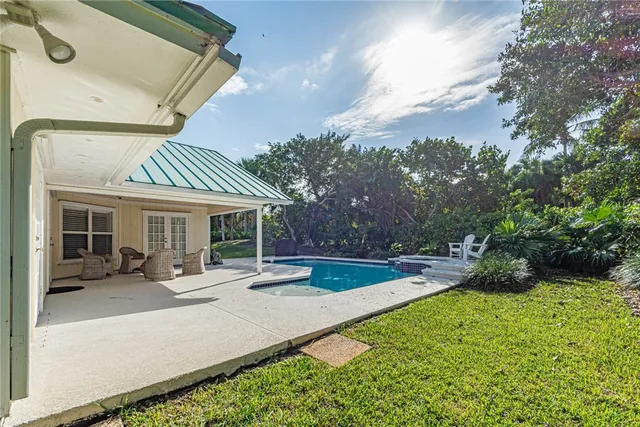 a view of a house with backyard and sitting area