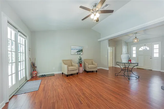a living room with furniture and a wooden floor