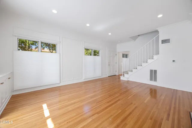 a view of an empty room with wooden floor