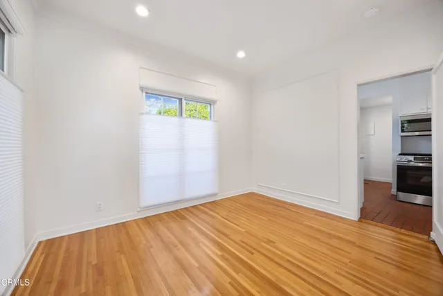 a view of empty room with wooden floor