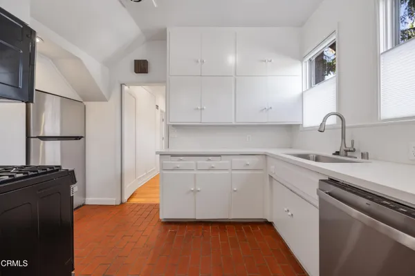a kitchen with white cabinets and appliances