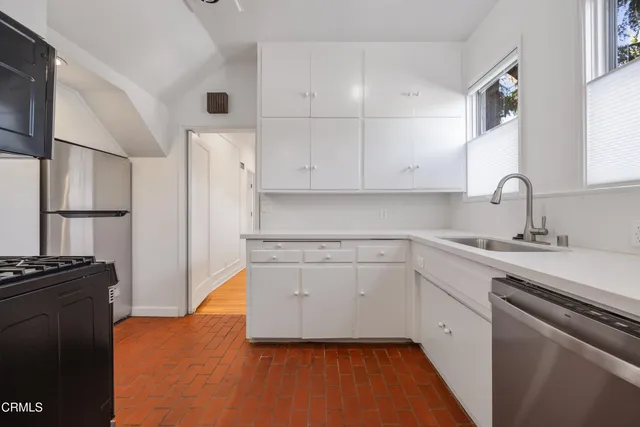 a kitchen with white cabinets and appliances
