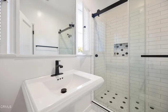 a bathroom with a sink a mirror and shower