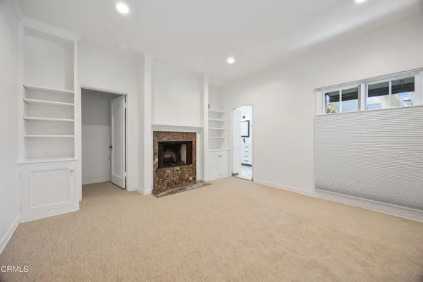 an empty room with a fireplace and cabinet