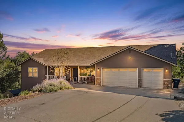 a front view of house with yard and trees around