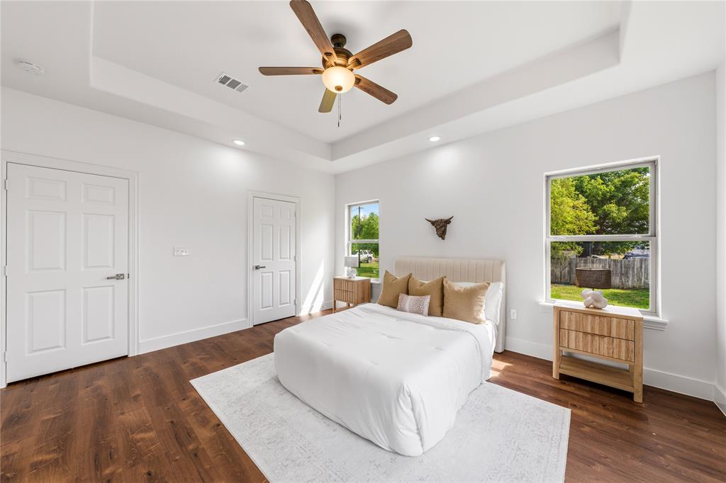 1128 Newton Road Ferris, TX 75125 - Photo 16 of 28 Spacious room featuring wood-finish flooring, a tray ceiling with a ceiling fan, recessed lighting, and two windows