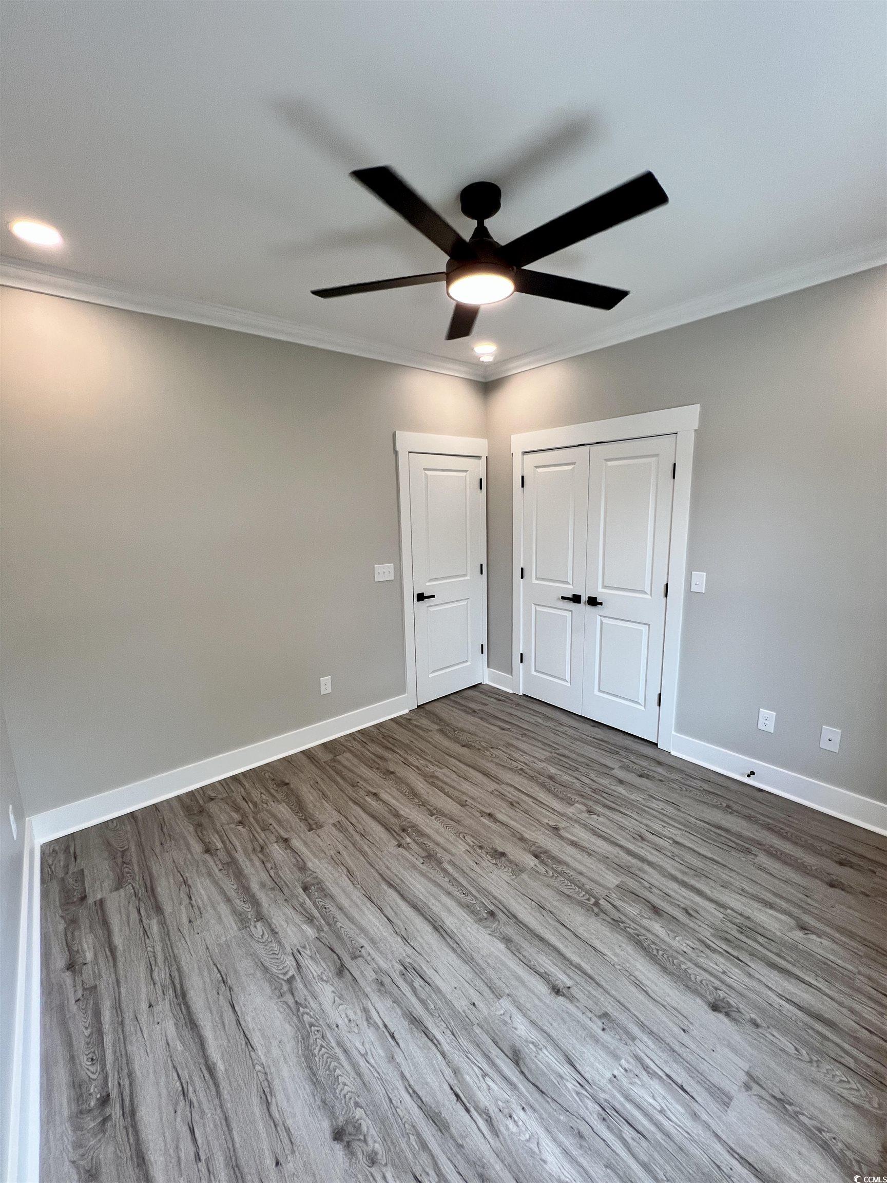 1795 Hemingway Street Conway, SC 29527 - Photo 18 of 29 Unfurnished bedroom featuring wood finished floors, crown molding, a closet, and a ceiling fan