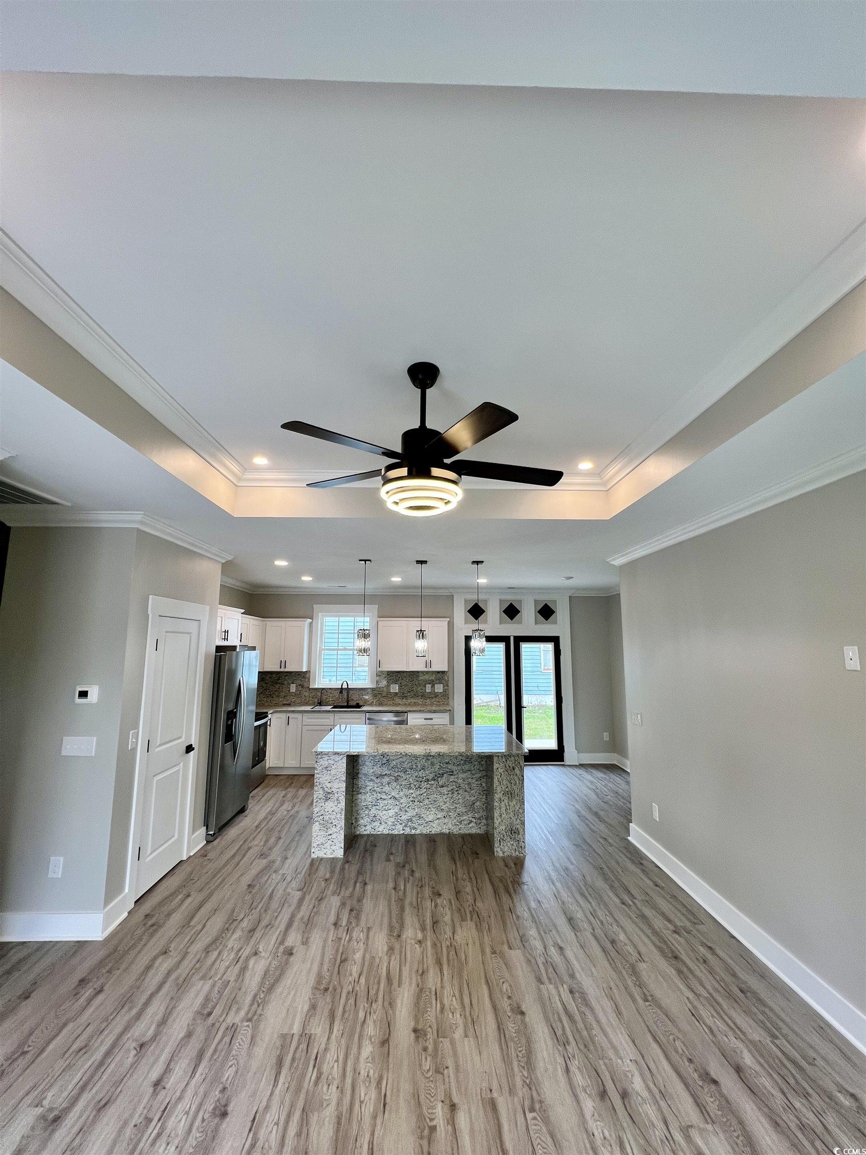 1795 Hemingway Street Conway, SC 29527 - Photo 4 of 29 Kitchen with a raised ceiling, crown molding, pendant lighting, a center island, and white cabinets