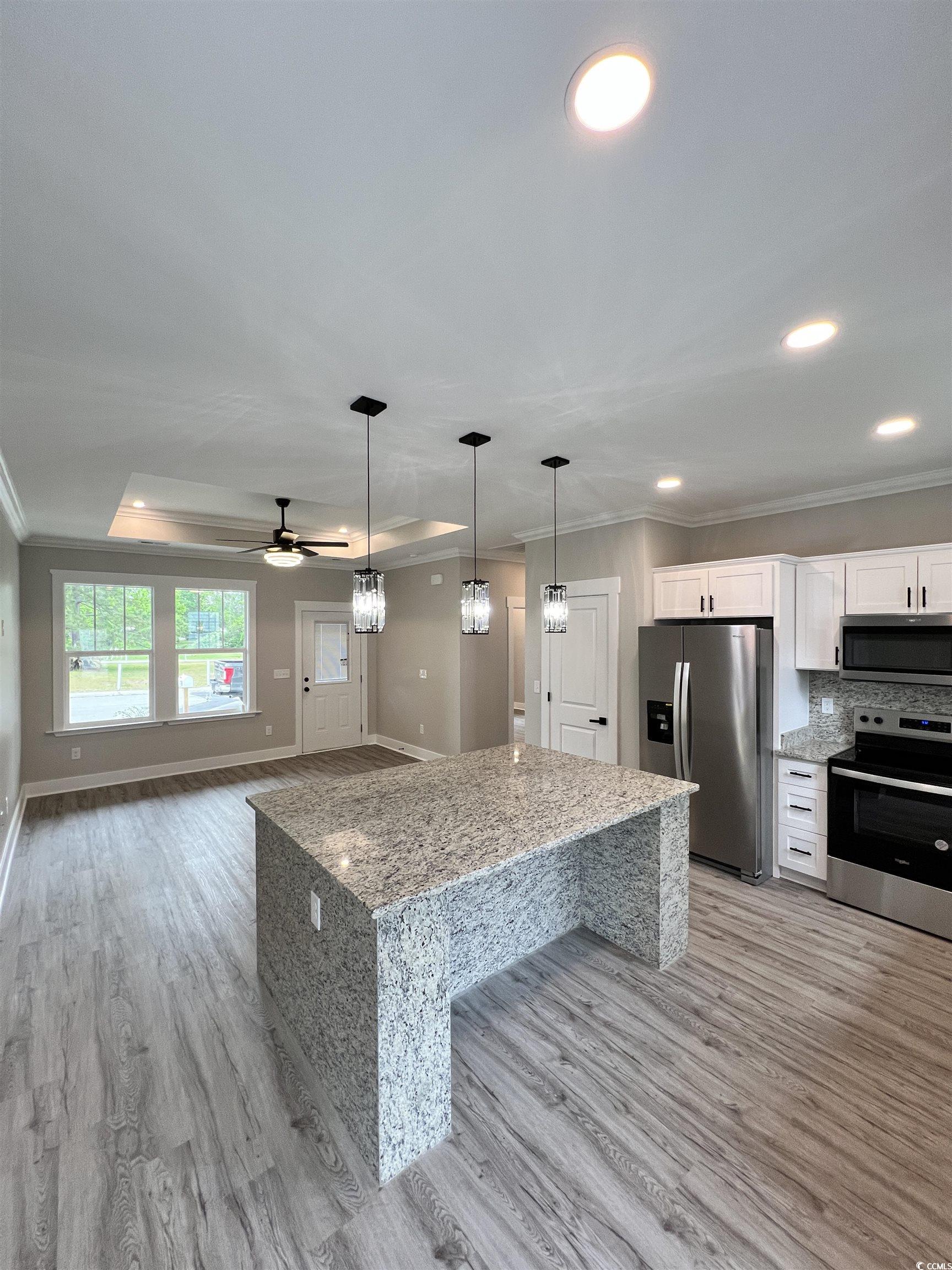 1795 Hemingway Street Conway, SC 29527 - Photo 5 of 29 Kitchen featuring ornamental molding, stainless steel appliances, light stone countertops, white cabinetry, and pendant lighting