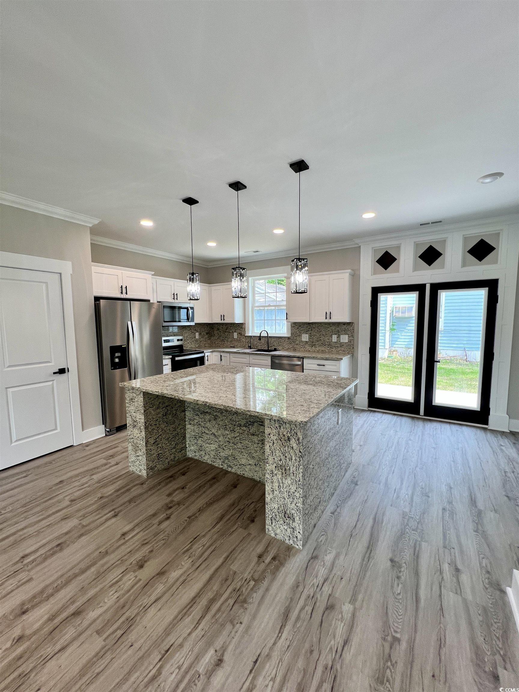1795 Hemingway Street Conway, SC 29527 - Photo 8 of 29 Kitchen featuring backsplash, a kitchen island, pendant lighting, white cabinetry, and stainless steel appliances