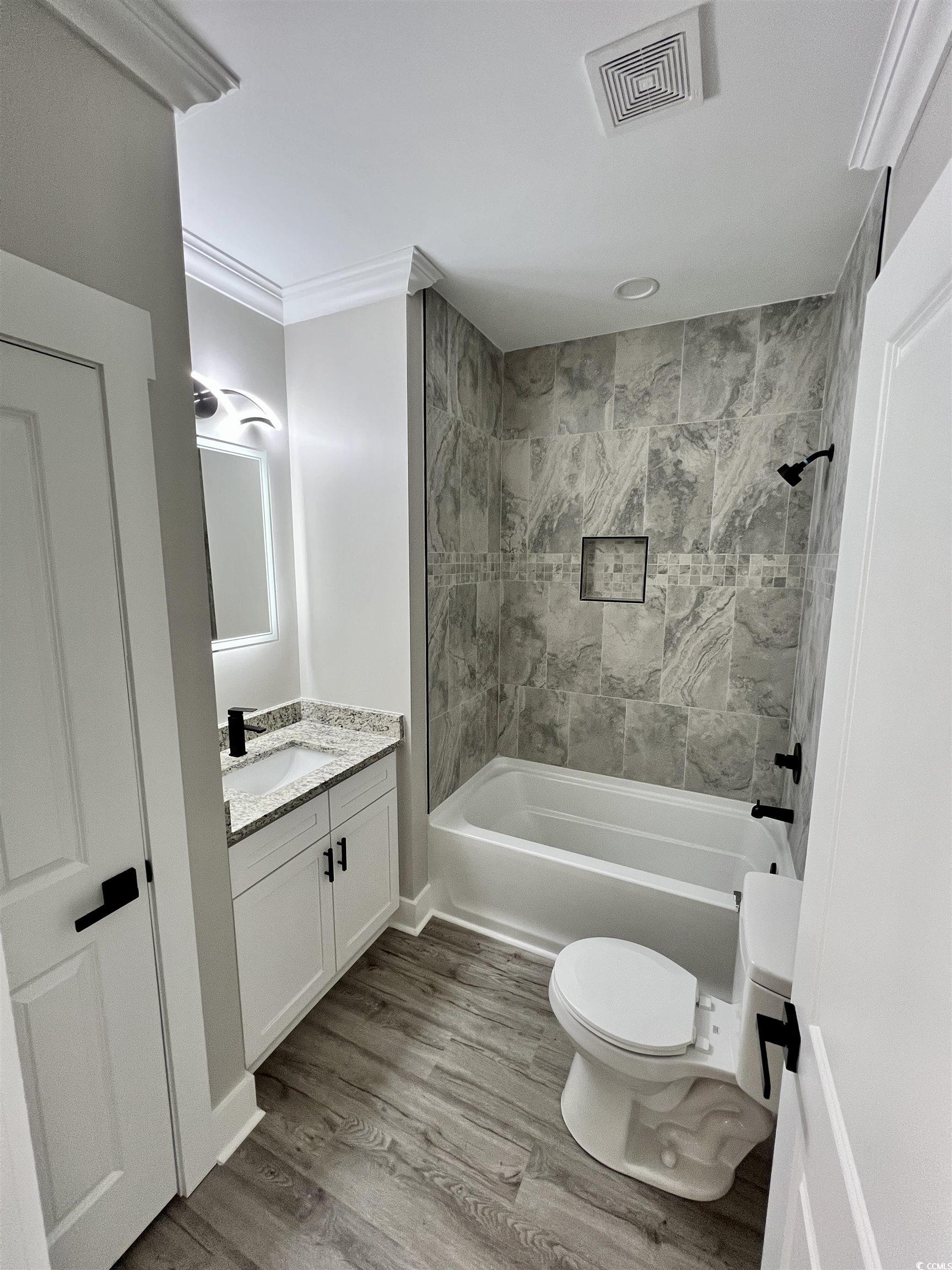 1795 Hemingway Street Conway, SC 29527 - Photo 9 of 29 Bathroom with tub / shower combination, vanity, and light wood finished floors