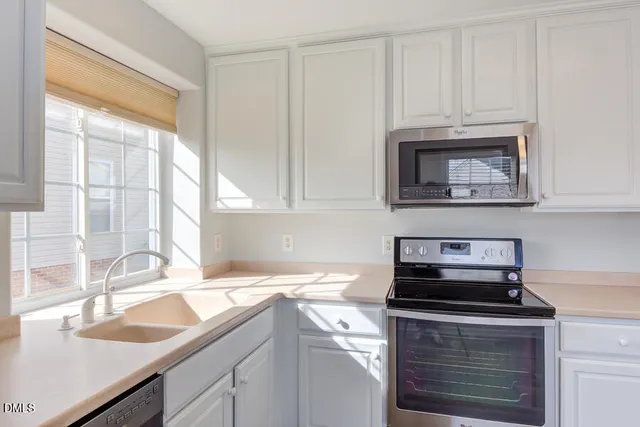 a kitchen with granite countertop white cabinets and a sink