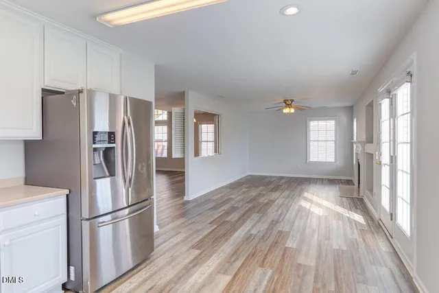 a kitchen with stainless steel appliances a refrigerator and wooden floor