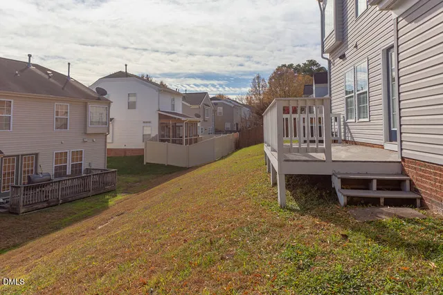 a view of a house with wooden deck and furniture