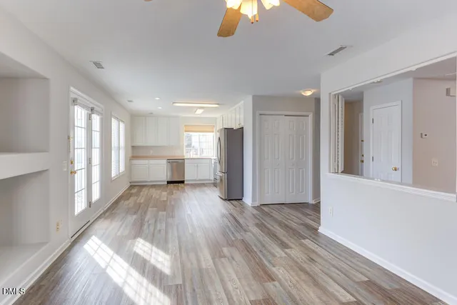 a view of a big room with wooden floor and windows