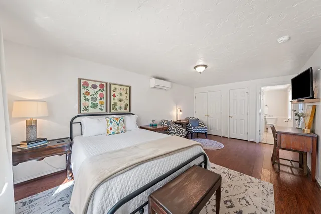 a bedroom with a bed a couch and a flat screen tv