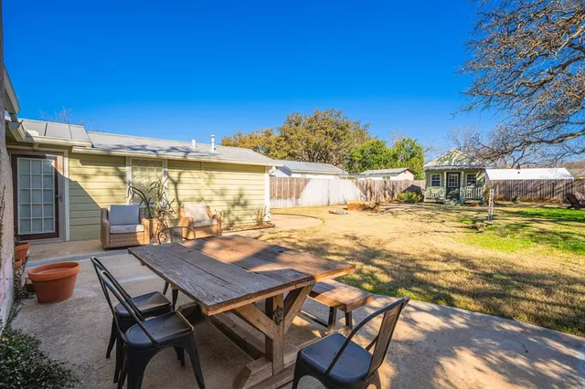 a view of a patio with table and chairs with wooden floor and fence