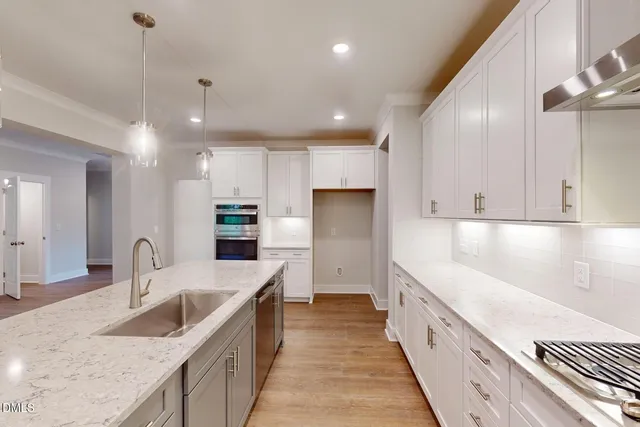 an empty room with wooden floor fireplace and windows