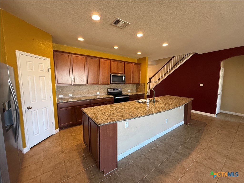 5607 Siltstone Loop Killeen, TX 76542 - Photo 7 of 48 a kitchen with stainless steel appliances granite countertop a sink a stove and a refrigerator