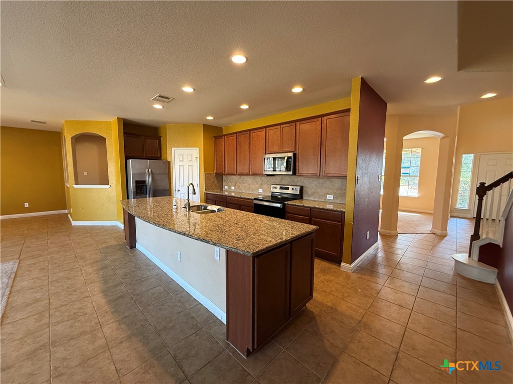 5607 Siltstone Loop Killeen, TX 76542 - Photo 9 of 48 a kitchen with stainless steel appliances granite countertop a large counter top a sink and a refrigerator