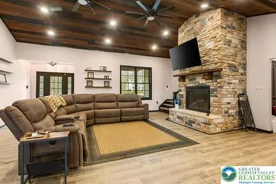 a living room with furniture a flat screen tv and a fireplace